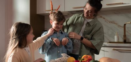 Mother and children have fun unpacking vegetables in the kitchen.
